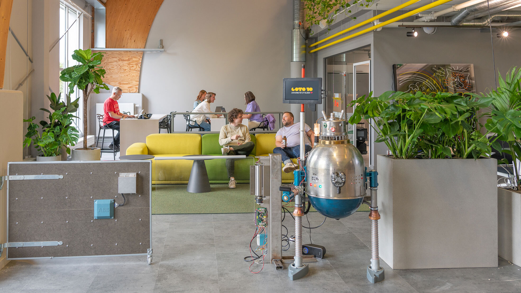 Vy över Goto 10:s co-working space i Linköping. Människor som sitter och jobbar och pratar med varann.